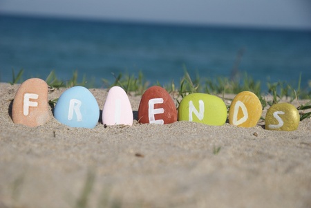 friends word on colourful pebbles over the sandの写真素材