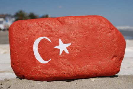 Turkey flag colours painted over a stoneの写真素材