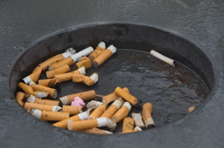public ashtray with smoked cigarettesの写真素材
