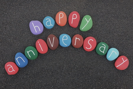 Happy Anniversary text with colored sea stones over blackの写真素材