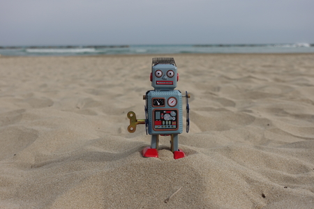 Tin toy retro robot on the beachの写真素材
