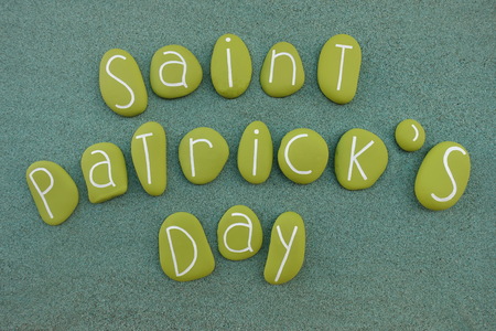 Saint Patrick's Day text composed with green colored stones over green sandの写真素材