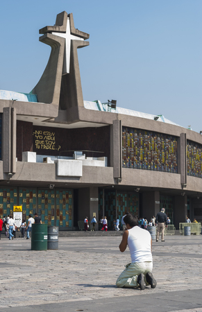 Mexico City, Mexico - May 25, 2011: A pilgrim prays on his knees before the Basilica of Our Lady Guadalupe. This church is one of the most popular pilgrimage sites of Catholicism around the world. The new Basilica was built in 1976, next to the old one.のeditorial素材