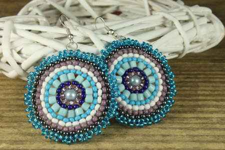 Pair of blue earrings on wooden backgroundの写真素材