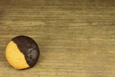 Biscuit with chocolate icing on wooden background