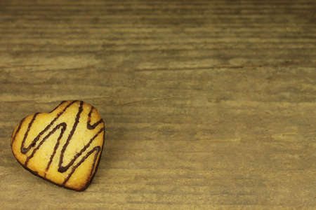 Biscuit with chocolate icing on wooden backgroundの写真素材