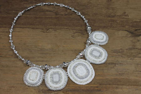 Beautiful white necklace in detail on wooden backgroundの写真素材