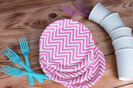 Plastic forks and paper plates and cups on wooden backgroundの写真素材