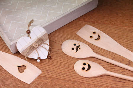 Funny wooden spoons with salver and decorative heart on wooden backgroundの写真素材