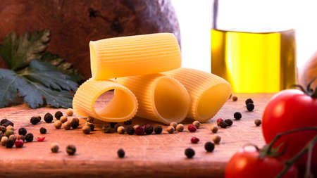 Paccheri dry pasta of the Italian tradition. Composition on wooden board.の写真素材