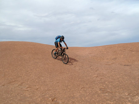 Mountain biker riding downhill the famous Slickrock trail, Moab, Utah, USAの写真素材