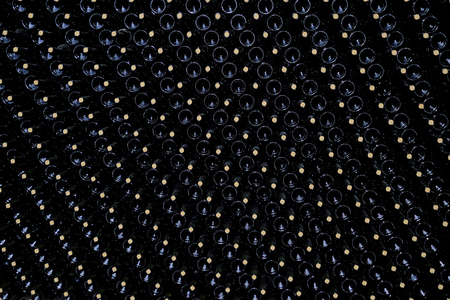 Resting wine bottles stacked in the cellar of a Malbec winery factory, San Juan, Argentina, South America, also seen in Mendozaの写真素材