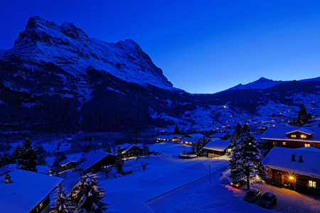 Grindelwald village at dusk with Mt. Eiger peak in the background, snow covered landscape in winter, Grindelwald, Bern, Switzerland, Europeの写真素材