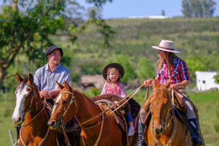 CAMINOS, CANELONES, URUGUAY, OCT 7, 2018: Gaucho family riding on horses at a Criolla Festival in Uruguay, South America, also been seen in Argentina, Brazil and Chileのeditorial素材
