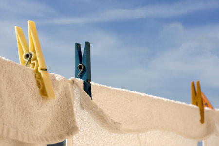 Dry  towels and pegs with blue sky in background