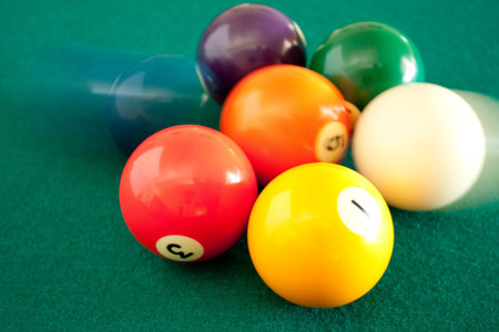 Colorful balls moving on green billiard table