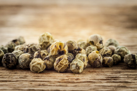 Dry green peppercorn  on wooden background macro