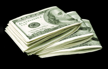 Three bundles of hundred-dollar bills over a black background