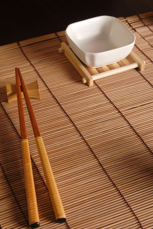 Bamboo mat, dish with its base and chopsticks composition.の写真素材
