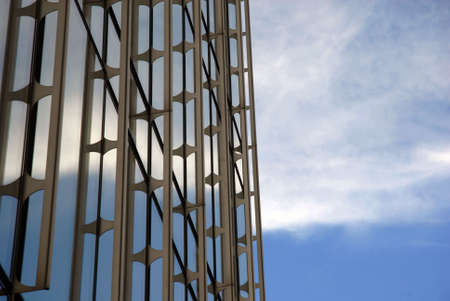 Architectural detail of a contemporary building reflecting a cloudy skyの写真素材