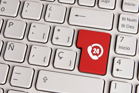 Spanish keyboard with 24 hours call support service phone icon over red background button. Image...