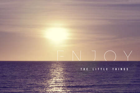 Enjoy the little things motivational inspiring quote concept with soft light summer sunset landscape background ideal for print card and poster design.の写真素材