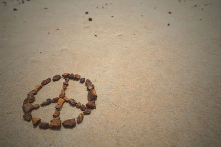 Peace symbol made with rocks on beach sand. Summer hipster background.の写真素材