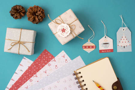 Merry Christmas season concept stationery mockup top view set template: empty paper notebook with pencil, vintage gift boxes, labels and stationery elements.の写真素材