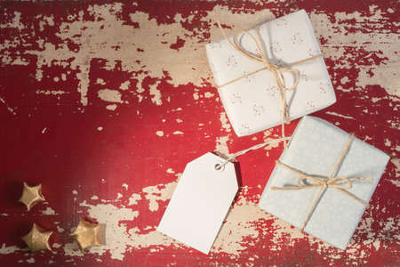 Holiday greeting card concept, top view retro gift boxes with empty label mockup template on grunge texture background. Includes clipping path.の写真素材
