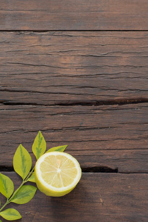 Rustic wood table background with cooking ingredients, fresh lemon and leaves on empty wooden surface template.の写真素材