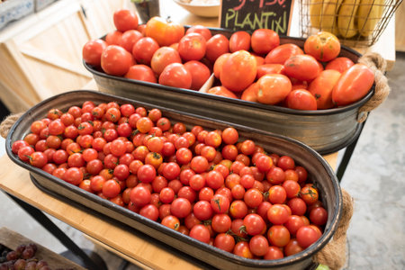 Red tomatoes display in food market, organic tomato boxes for sale at natural vegetable shop....