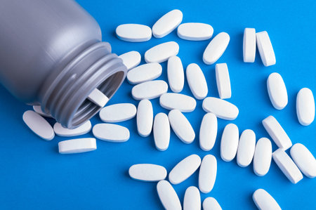 pills of medications or nutritional supplements pouring a bottle of prescription open