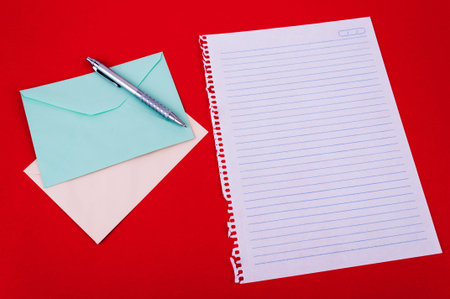 envelope of correspondence, pen and blank notebook sheet