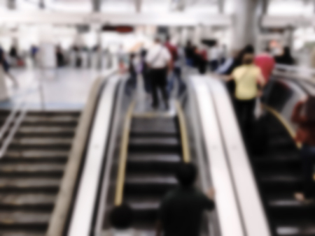 People walking on the escalator in subway station. Intentional blurred added post production. Creative abstract background with blurred in modern style.の写真素材