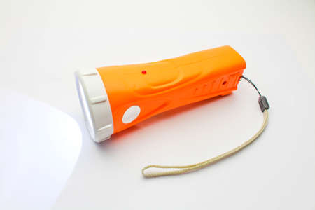 Flashlight with a light on white の写真素材