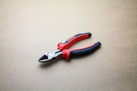 Plier tool isolated on seamless brown paper backgroundの写真素材