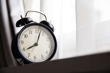 Alarm clock with curtain on backgroundの写真素材