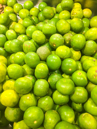 Pile of a green fresh lemons, shot in supermarket