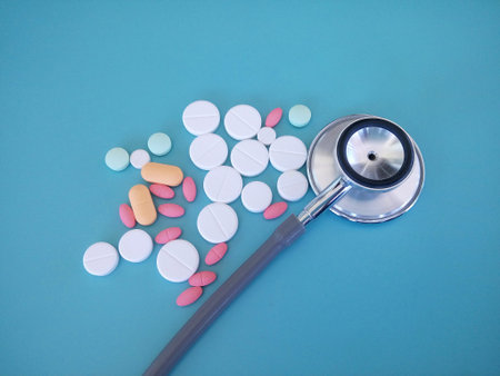 stethoscope and pills isolated on the blue background