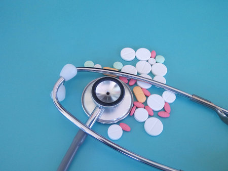 stethoscope and pills isolated on the blue background