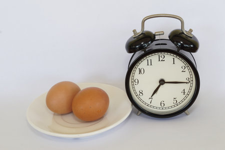 chicken eggs with alarm clockの写真素材