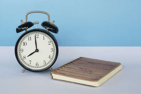 alarm clock and book on the tableの写真素材