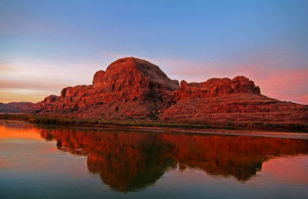 Red rock reflections on the Colorado River with blue skysの写真素材