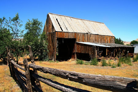 View of a hay barn eit a wood fense in the forgroundの写真素材
