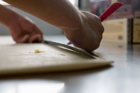 Photos taken at a local bakery showing a baker hand cutting freshly made croissant Doughの写真素材