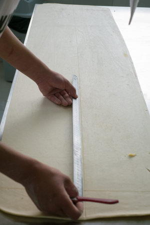 A local baker prepping classic croissant to be cut and then rolled.