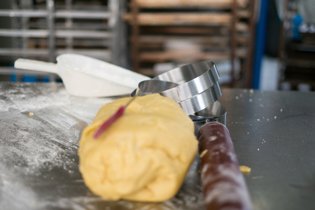A stack of stainless steel rings next to a was of pie crust cuttings.の写真素材