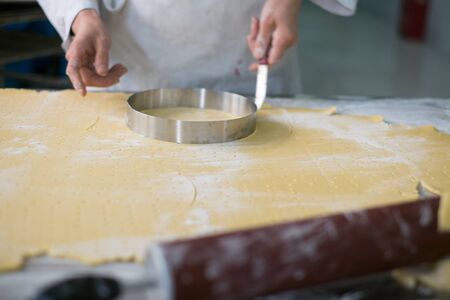 Local baker cutting pie crusts for the morning prep work.の写真素材