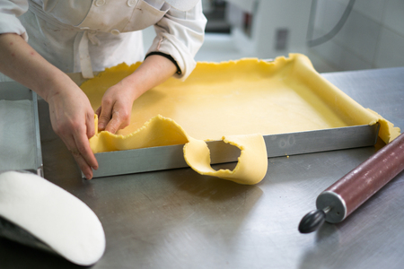 Photos taken at a local bakery showing freshly made pie dough being cut by a local bakerの写真素材