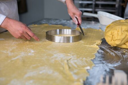 Pastry chef cutting freshly rolled pie crust or pie dough.の写真素材